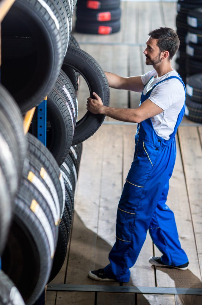 Mechanic taking out a tyre from stock - Order Tyres Online Abingdon