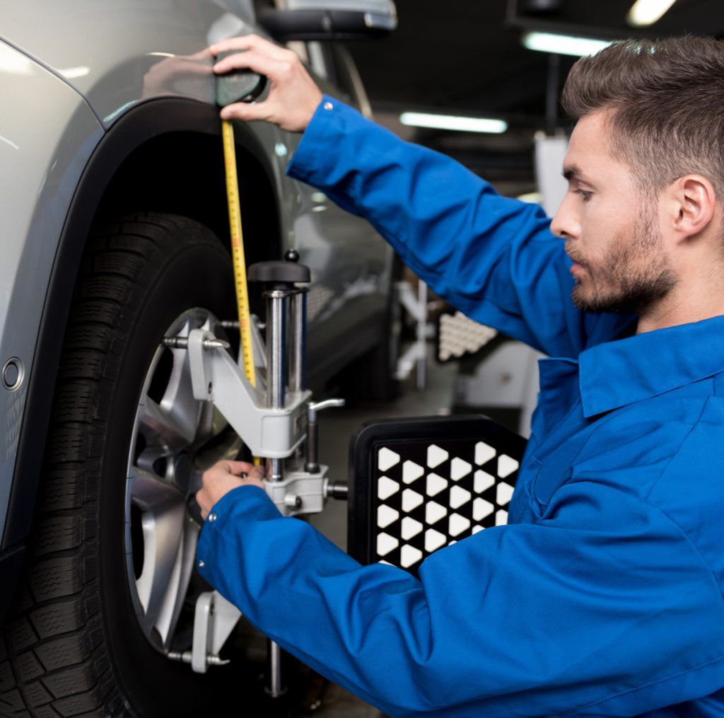 Mechanic checking tyres alignment - Wheel Alignment Abingdon